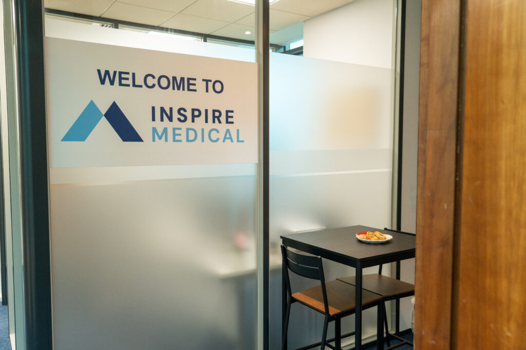 The Inspire Medical welcome panel beside a small seating area in the office