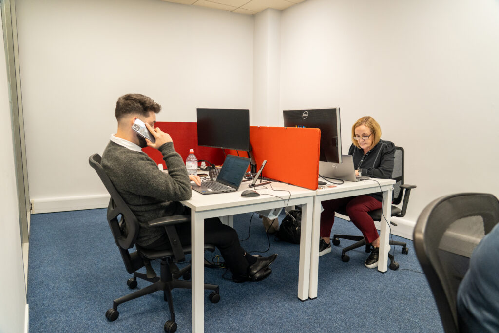 Two Inspire Medical consultants at work, one taking a call at his desk